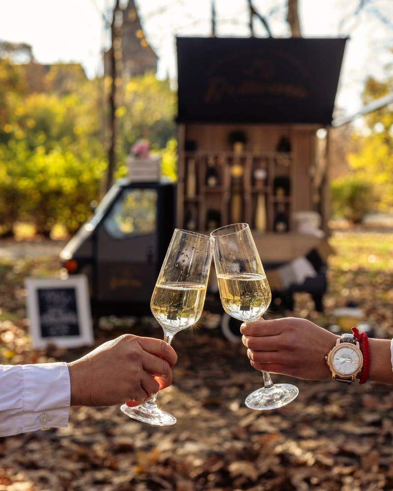 Koccintás két pohár proseccóval a Bollicina Ape előtt