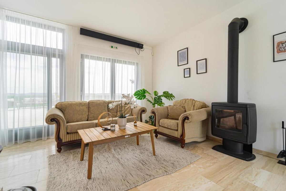 A nappali ülőgarnitúrája a panorámaablak mellett